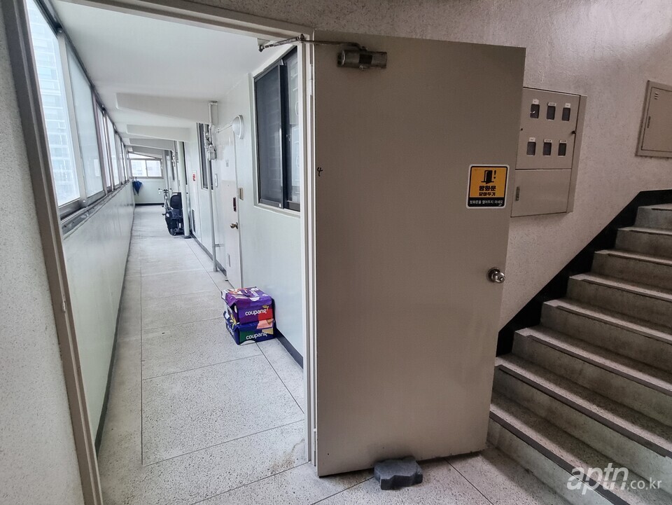 한 아파트 복도에 방화문이 벽돌로 받혀진 채 열려 있다.  [서지영 기자]