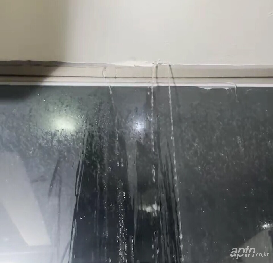 아파트 복도 창틀에서 빗물이 복도 쪽으로 새고 있는 모습. [아파트관리신문]