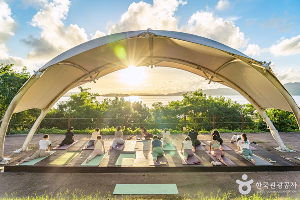 강화유니버스 참가자들이 강화도의 노을을 배경으로 요가를 하고있는 모습