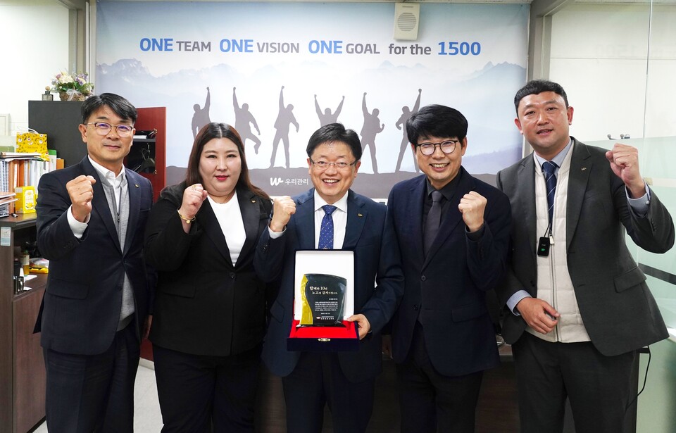 (왼쪽부터) 우리관리 최창해 그룹장, 문유경 관리소장, 나상인 영업부문장, 김기문 본부장, 최정복 매니저가 광주이편한세상광주역3단지의 감사패 전달식 후 기념촬영을 하고 있다. [사진=우리관리]